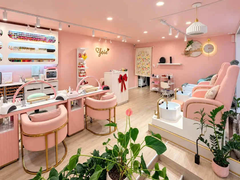 Joie Nails & Beauty salon with blush pink manicure chairs, pedicure seating and greenery